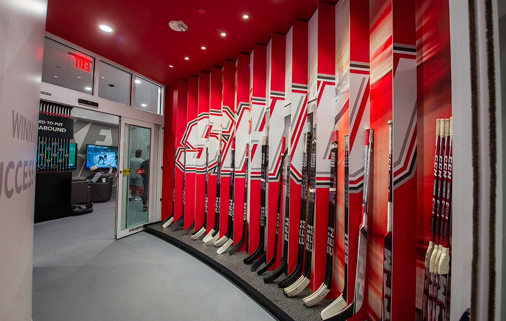 lenticular red wall graphics on hockey stick cubbies in front of a glass doorway